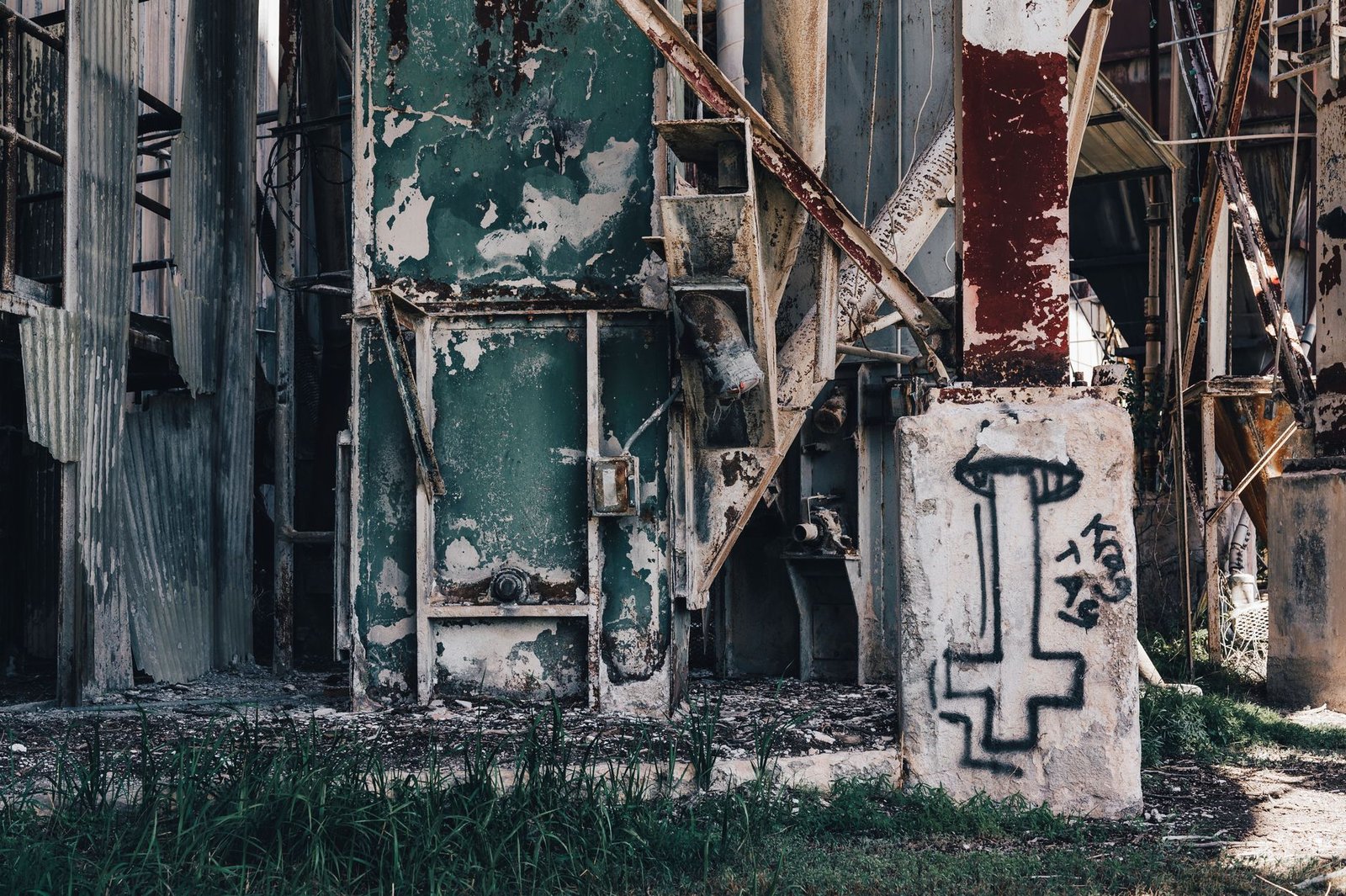Close-up of a decaying factory facade covered in rust and graffiti.