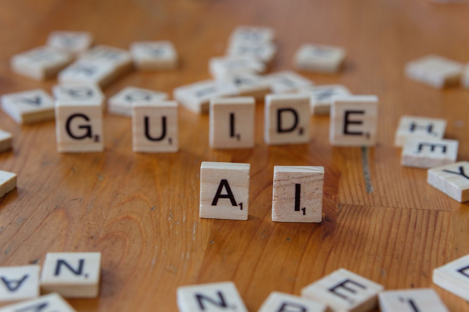 Scrabble letters spelling 'GUIDE' and 'AI' on a wooden surface, suggesting direction and technology.